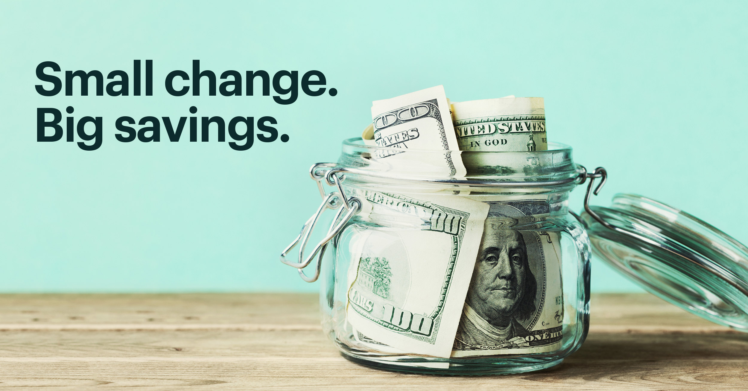  Jar of Money on a Wooden Table with Text That Reads: Small Change. Big Savings